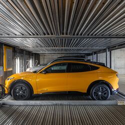 Bildet viser en bil på en plattform i et automatisert parkeringssystem i en moderne parkeringskjeller.