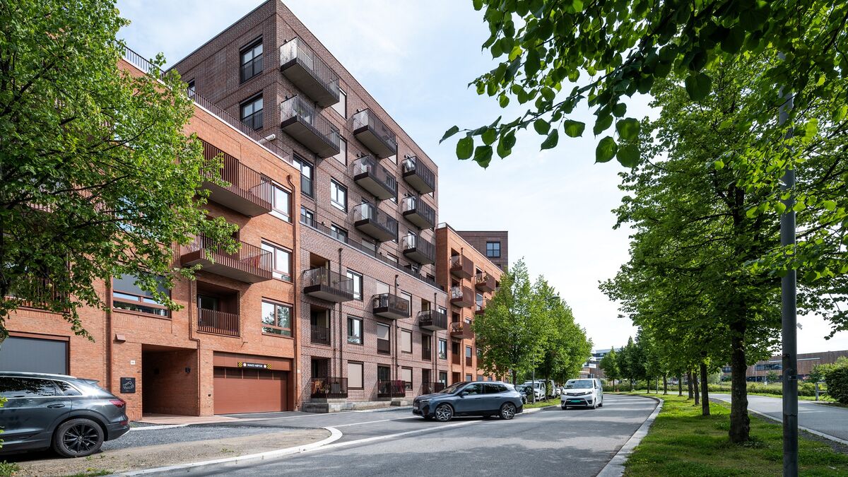 Moderne boligområde der et kjøretøy kjører inn i en garasje utstyrt med et integrert parkeringssystem.