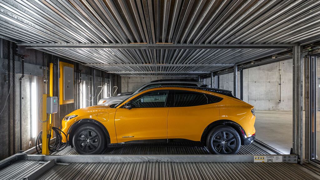 Bildet viser en bil på en plattform i et automatisert parkeringssystem i en moderne parkeringskjeller.