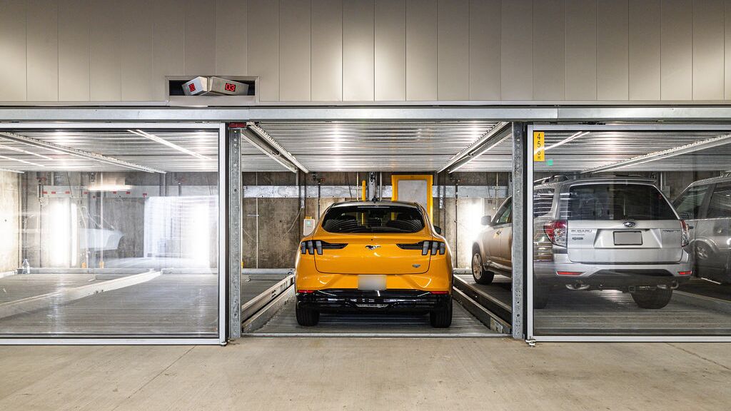 Bildet viser en moderne parkeringskjeller med flere innglassede parkeringsplasser i et parkeringssystem.