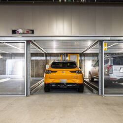 Bildet viser en moderne parkeringskjeller med flere innglassede parkeringsplasser i et parkeringssystem.